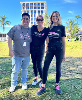 group of friends at breast cancer charity event smiling arm in arm