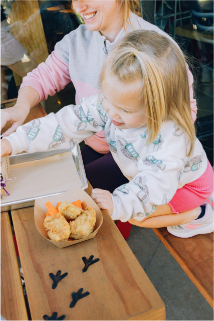 young girl happily eating crack shack kids meal