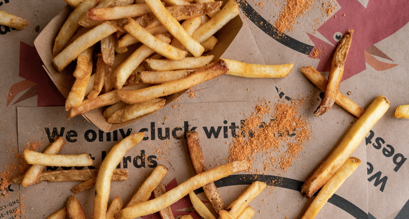 Fries in a boat and on tray with seasoning around
