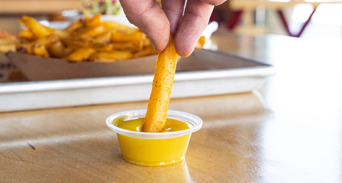 Fry dipping into pineapple mustard sauce.