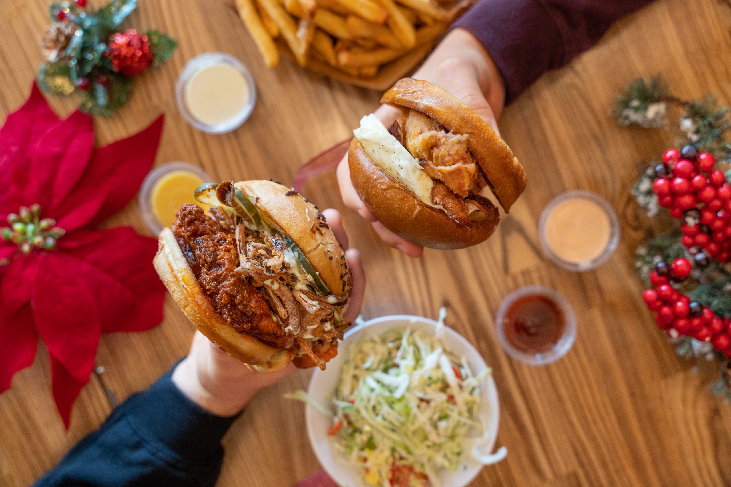 Sandwiches being held over table decorated with holiday decor.