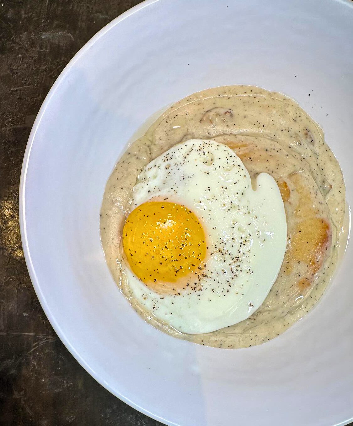 Fried egg on top of biscuit and gravy