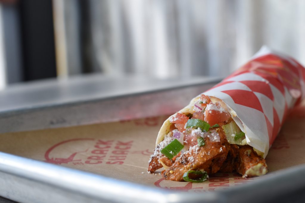 Chicken wrap with a checkered wrapping around it on a tray.