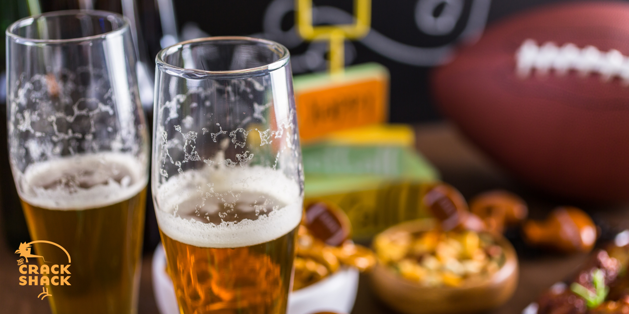 The Crack Shack logo on a photo of beers, food, and a football on a table.
