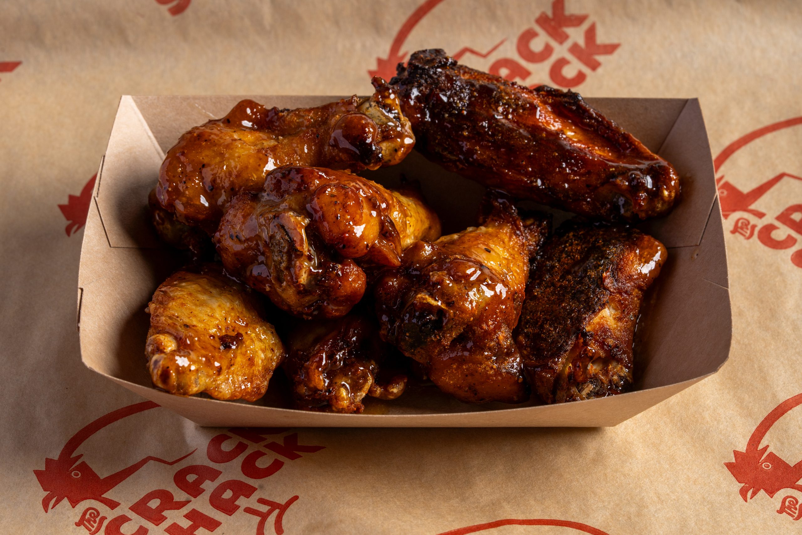 chicken wings with sauce on top in a boat