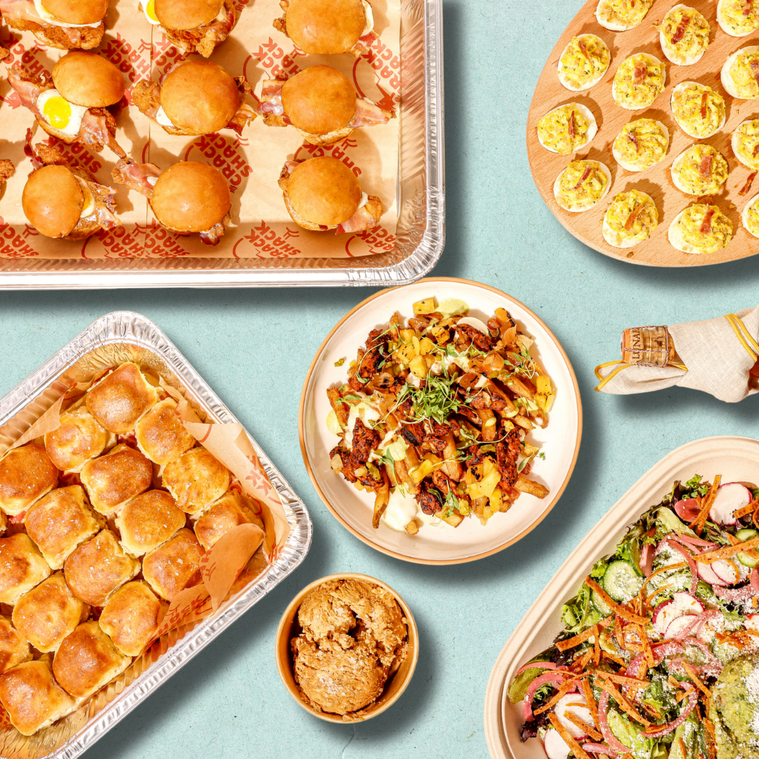 Trays of catering food on a blue background.