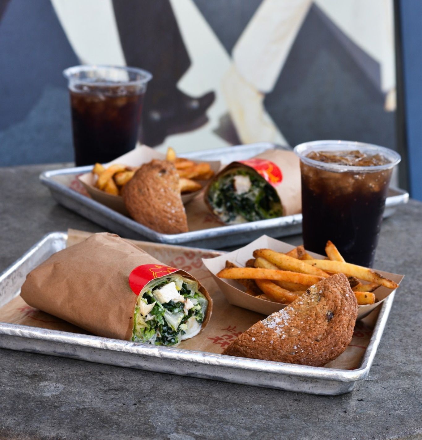 Caesar wrap, fries, half a cookie, and a fountain drink on a tray.