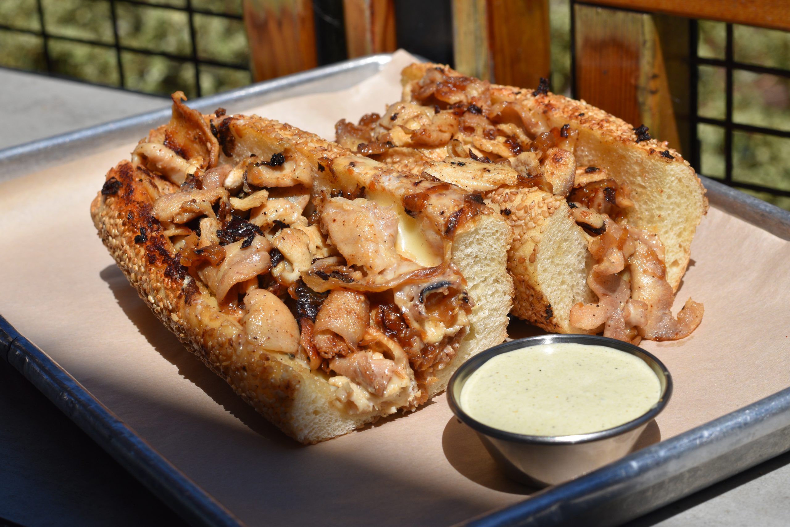 Chicken cheesteak with onions on a tray.
