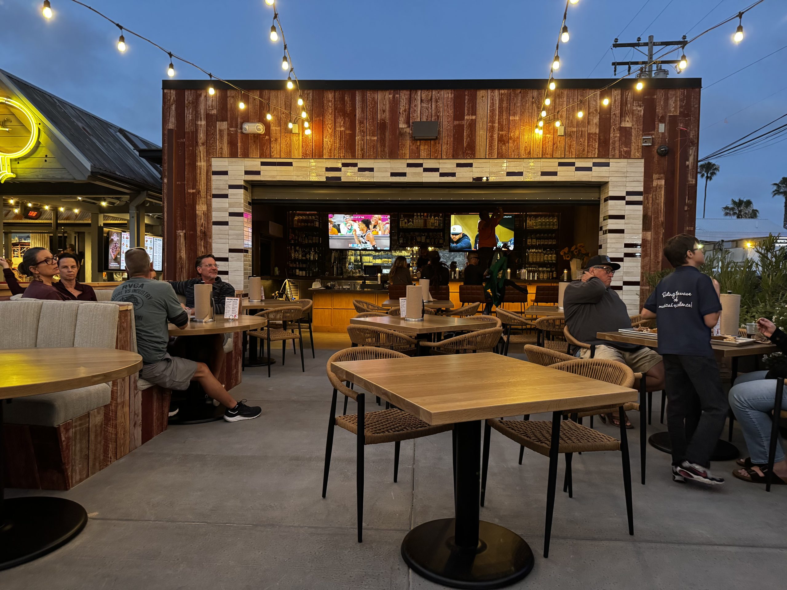 People sitting in an outdoor patio space at tables.